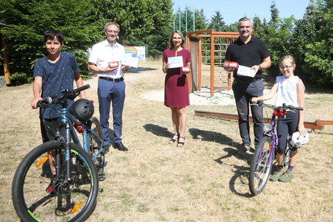 Landesrat Mag. Heinrich Dorner (2.v.r.) mit HR Mag. Jürgen Neuwirth (Bildungsdirektion Burgenland, Bereich Pädagogischer Dienst) in Vertretung von LRin Mag.a (FH) Daniela Winkler und DI Sabine Kaulich vom Kuratorium für Verkehrssicherheit (v.l.) mit den Kindern Simon (l.) und Anja (r.)