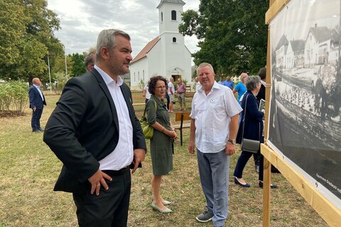 Landesrat Mag. Heinrich Dorner betrachtet anlässlich der Jubiläumsfeierlichkeiten eine historische Aufnahme von Lindgraben