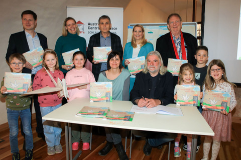 Präsentierten das Kinderbuch „Der Kranich und das DU“ im Rahmen eines Workshops mit Kindern der Volkschule Statdtschlaining: Bildungslandesrätin Daniela Winkler (2. Reihe, 2.v.r.), Autor Heinz Janisch (1. Reihe), Illustratorin und Grafikerin Nadine Kappacher (1. Reihe), Klaus Novak (2. Reihe, 3.v.r.), Leiter des Instituts für Fort- und Weiterbildung an der Privaten Pädagogischen Hochschule Burgenland, Horst Horvath (2. Reihe, 1.v.r.), Verlagshaus edition lex liszt 12, Tobias Lang (2. Reihe 1.v.l.), dem neuen Direktor des Austrian Centre for Peace und Direktorin Eva Schitter (2. Reihe, 2.v.l.) , Volksschule Stadtschlaining