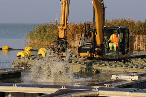 Amphibienbagger bei Arbeiten im Hafen von Podersdorf beim Pilotprojekt zur Schlamm- und Schilfbeseitigung.