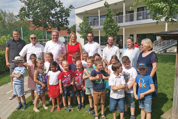 Bildungslandesrätin Daniela Winkler (Mitte) mit Bgm. Gerhard Zapfl (3.v.l.), Vizebürgermeister Helmut Pecher (5.v.l.), weiteren Vertretern der Gemeinde und der Kindergarten und Kindern des neuen Kindergartens