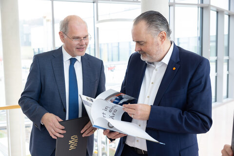 Geschäftsführer Franz Öller und Landeshauptmann Hans Peter Doskozil beim Schmökern im Bildband