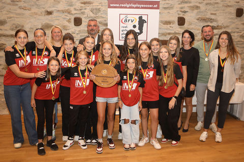 Nina Potz, Trainerin der Damenmannschaft des SC Neusiedl (hinten links) und BFV-Frauenfußballreferentin Yvonne Lindner (3.v.r., stehend) überreichten gemeinsam mit Sportlandesrat Heinrich Dorner (2.v.l., hinten) die Medaillen an das beliebteste Nachwuchsteam, die Mädchen des ASV Draßburg.