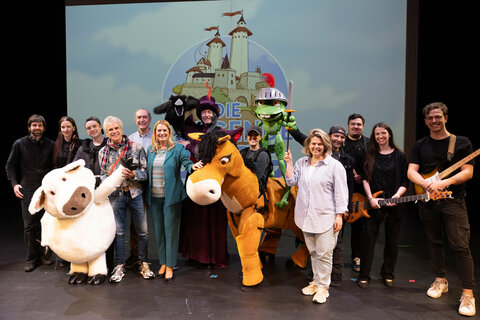 Landesrätin Daniela Winkler (6.v.l.), Autor Thomas Brezina (4.v.l.), Komponist Gerhard Krammer (5.v.l.) und Claudia Priber, Geschäftsführerin der Kultur-Betriebe Burgenland GmbH (5.v.r.) mit Ensemble-Mitgliedern des Musicals „Die fliegende Burg“.