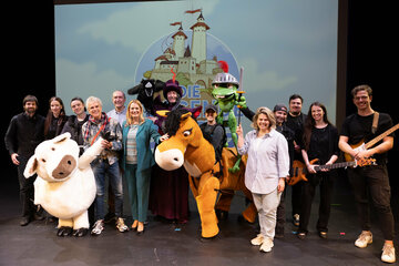 Landesrätin Daniela Winkler (6.v.l.), Autor Thomas Brezina (4.v.l.), Komponist Gerhard Krammer (5.v.l.) und Claudia Priber, Geschäftsführerin der Kultur-Betriebe Burgenland GmbH (5.v.r.) mit Ensemble-Mitgliedern des Musicals „Die fliegende Burg“.