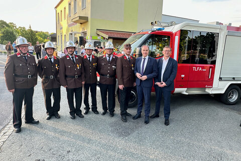 Landesrat Dr. Leonhard Schneemann mit Ortsfeuerwehrkommandant Dietmar Rudolics und Mitgliedern der Feuerwehr Zuberbach-Podler vor dem neuen Feuerwehrfahrzeug.