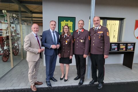 Landesrat Leonhard Schneemann mit Vertreterinnen und Vertretern der Feuerwehr sowie weiteren Ehrengästen vor dem neuen Feuerwehrhaus in Neuhaus am Klausenbach.
