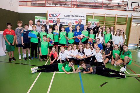 Burgenlands Leichtathletik-Präsident Rolf Meixner, Bernd Varga vom Verein LAC Aschau, Fachinspektor für Bewegung und Sport Harald Ziniel, Sportlandesrat Heinrich Dorner, Sportkoordinatorin Yvonne Weinhandl, Direktor Daniel Karacsonyi, Direktor-Stellvertreter und Sportkoordinator Stefan Wessely, und Sportwissenschafter Johann Szabo (v.l., hinten) mit Schülerinnen und Schülern in der Sportmittelschule Oberschützen.