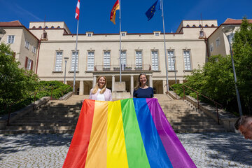 Landeshauptmann-Stellvertreterin Anja Haider-Wallner und Landesrätin Mag.a (FH) Daniela Winkler (v.r.) mit der Regenbogenfahne vor dem Landhaus Alt.