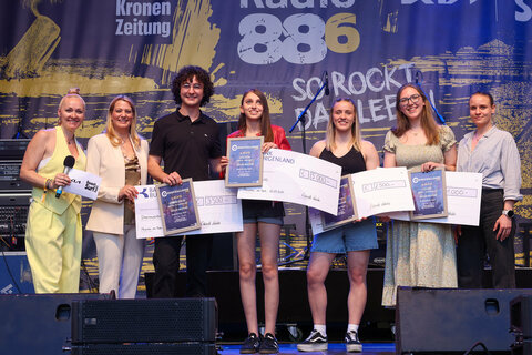 Moderatorin Rozalija Gregurek, LRin Mag.a (FH) Daniela Winkler, Zweitplatzierter Benjamin Gedeon, die strahlende SongChallenge-Siegerin Sofia Reyna, die Preisträgerinnen Lizalu und Lisa Seidl sowie Mag.a Bianca Benedikt, MA, Leiterin des Landesjugendreferats, bei der Siegerehrung.