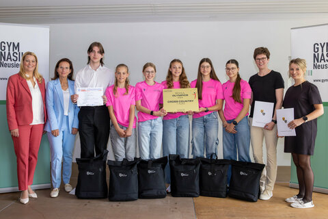 LRin Mag.a (FH) Daniela Winkler mit der Direktorin des BG/BRG Neusiedl, OStRin Mag.a Tanja Bayer-Felzmann,  Viktor Aubrecht, dem Bundesmeister der AMOPA Sprachmania 2025, den Bundesmeisterinnen im Schul Olympics Cross Country 2024 Anna Haubenwallner, Lieselotte Gettinger, Greta Bohrer, Stella Bohrer und Lisa Zechner mit ihren Lehrerinnen Mag.a Lisa Mauersics und Mag.a Theresa Wagner.