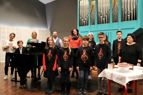 Landesrätin Mag.a (FH) Daniela Winkler gemeinsam mit Kristina Buconjic und Reinhold Bieber sowie Enrico Sieber und Mitwirkenden am Schulchor der Neuen Mittelschule Horitschon, darunter auch Pädagogin Marianne Prenner.