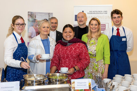 Ehrenamtliche Vorsitzende Roselinde Strommer (Katholische Frauenbewegung, kfb), Generalvikar MMag. Theol. Michael Wüger, Projektpartnerin Glorie Vi Seno, Superintendent Dr. Robert Jonischkeit und Landesrätin Daniela Winkler mit Schülerinnen und Schülern des Pannoneum Neusiedl am See (v.l.) beim Benefiz-Fastensuppenessen im Martinussaal der Diözese Eisenstadt.