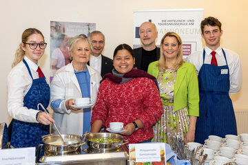 Ehrenamtliche Vorsitzende Roselinde Strommer (Katholische Frauenbewegung, kfb), Generalvikar MMag. Theol. Michael Wüger, Projektpartnerin Glorie Vi Seno, Superintendent Dr. Robert Jonischkeit und Landesrätin Daniela Winkler mit Schülerinnen und Schülern des Pannoneum Neusiedl am See (v.l.) beim Benefiz-Fastensuppenessen im Martinussaal der Diözese Eisenstadt.