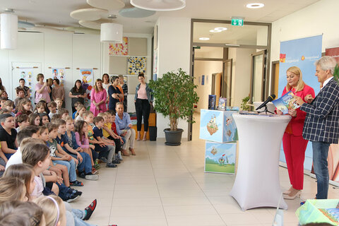 Bildungslandesrätin Daniela Winkler und Autor Thomas Brezina lasen aus dem Buch „Die fliegende Burg“ vor und verteilten die ersten, vom Autor signierten Exemplare an die Kinder des Kindergartens und der VS Weiden am See