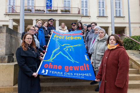 Landesrätin Daniela Winkler mit den Unterstützerinnen und Unterstützern der Aktion bei der Übergabe der Flagge gegen Gewalt an Frauen und Mädchen vor dem Landhaus-Alt in Eisenstadt.