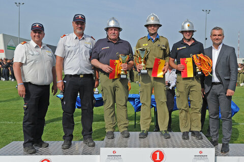 Landesrat Heinrich Dorner (r.), Landesfeuerwehrkommandant-Stellvertreter LBDS Martin Reidl, Landesfeuerwehrkommandant LBD Ing. Franz Kropf (v.l.) überreichten die Pokale und Medaillen an Markt St. Martin I (Gold, 3.v.r.), Hornstein I (Silber, 3.v.l.) und St. Martin an der Raab Berg (Bronze, 2.v.r.).