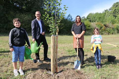 Naturschutzreferentin Landeshauptmannstellvertreterin Astrid Eisenkopf, Bürgermeister Andreas Gradwohl, Lea (mit dem Strudelkochbuch "Wir strudeln durch Sieggraben“) und Bleon aus der 3. Klasse der Naturpark-Volksschule Sieggraben mit dem von ihnen gepflanzten Apfelbaum.