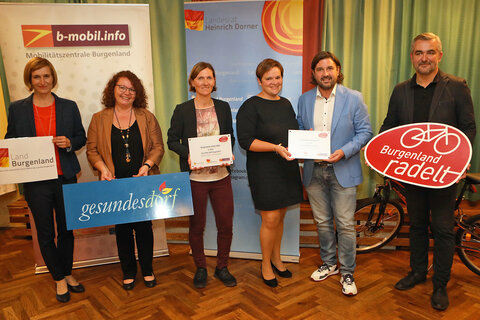 Christine Zopf-Renner (l.) und Landesrat Heinrich Dorner (r.) gratulierten der Gemeinde Oberschützen mit Bürgermeister Hans Unger (2.v.r.) und Gemeindebedienstete Elke Kainz (3.v.r.) sowie dem Gesunden Dorf Siegendorf mit Tina Wurm (3.v.l.) zum Sieg.