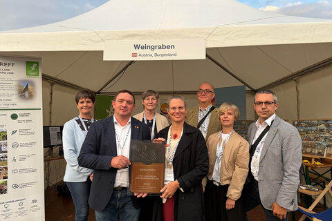 Landeshauptmann-Stellvertreterin Anja Haider-Wallner (vorne Bildmitte) und Bürgermeister Thomas Stoiber (2.v.l.) mit dem Europäischen Dorferneuerungspreis für den Dorftreff in Weingraben.