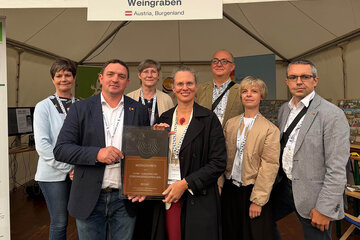 Landeshauptmann-Stellvertreterin Anja Haider-Wallner (vorne Bildmitte) und Bürgermeister Thomas Stoiber (2.v.l.) mit dem Europäischen Dorferneuerungspreis für den Dorftreff in Weingraben.