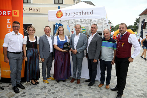 Frühschoppen Stadtschlaining: Kapellmeister Johann Knausz, Landesstabsführerin Stefanie Klein, Obmann DI Peter Reichstädter (alle Burgenländischer Blasmusikverband), Kapellmeisterin Laura Divosch (Musikverein Stadtschlaining), Landesrat Dr. Leonhard Schneemann, Stadtschlainings Bürgermeister Mag. Markus Szelinger, Franz Habetler (Gestalter der Trophäe, aus Bernstein) und Phillip Klein (MV Stadtschlaining) (v.l.).