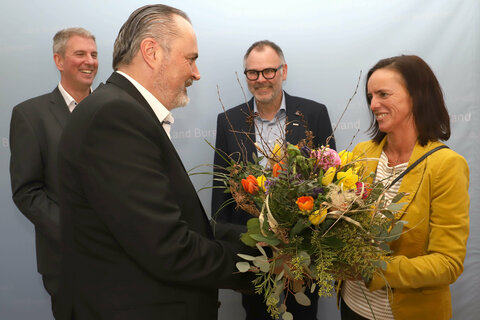 Innungsmeister-Stellvertreterin Michaela Grandits überreicht Landeshauptmann Mag. Hans Peter Doskozil einen Frühlingsblumenstrauß.