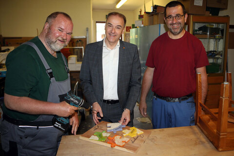 Harald Zumpf (Betreuung der Arbeitsgruppe Landwirtschaft) und ein Bewohner erklärten Landesrat Dr. Leonhard Schneemann (Mitte) ihre Arbeit im Wohnheim