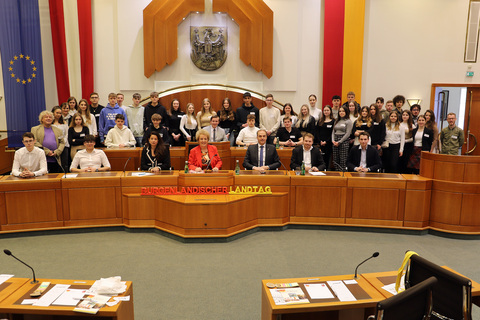 Landtagspräsidentin Verena Dunst (Mitte, vorne) mit Landesrat Leonhard Schneemann (3.v.r., vorne), Barbara Glück (3.v.l., vorne) sowie Jonathan Dorner (2. v. r., vorne) mit den Professoren sowie den Schülerinnen und Schülern im Landtagssitzungssaal.