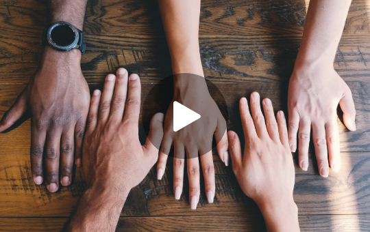 Händer auf einem Tisch die verschieden Herkünfte und Hintergründe anzeigen sollen