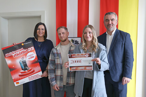 Landeshauptmann-Stellvertreterin Mag.a Astrid Eisenkopf und Landesrat Mag. Heinrich Dorner überreichen den Gutschein in der Höhe von 2.000 Euro für den dritten Platz an Stefanie Wertner und ihren Lebensgefährten.