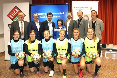 BFV-Präsident Gerhard Milletich, Bürgermeister Heinz-Peter Krammer, Landesrat Christian Illedits, Obfrau des FC Südburgenland, Christina Koch, Direktor Chris Wagner, Fachinspektor für Bewegung und Sport, Harald Ziniel und Fußball-Koordinator Joachim Steiner (hinten v.l.) mit Mädchen der Bundeshandelsakademie und Bundeshandelsschule Stegersbach (vorne).