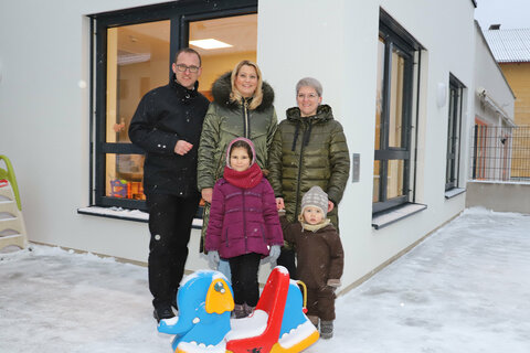 Vor dem Zubau zum Kindergarten, der die neue Kinderkrippe beherbergt – v.l.:  Bgm. Ing. Andreas Gradwohl, LRin Mag.a (FH) Daniela Winkler und Kindergartenleiterin Elisabeth Karner mit Kindern