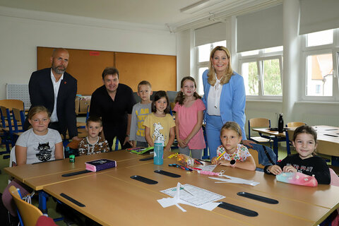 Dir. Bgm. Hannes Schmid, Clusterleiter Norbert Kappel und Bildungslandesrätin Mag.a (FH) Daniela Winkler (v.l.n.r.) besuchen eine Gruppe von Teilnehmerinnen und Teilnehmern.
