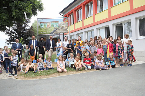 Gruppenfoto beim Spatenstich für den neuen Turnsaal mit allen Beteiligten sowie den Kindergartenkindern und Schülern.