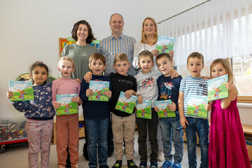 Bildungslandesrätin Daniela Winkler (stehend, rechts) mit Bürgermeister Karel Lentsch sowie Eveline Karner (hinten, v.r.) mit Kindern des KiGA Neudorf.