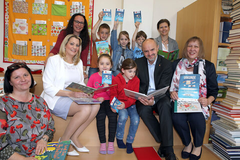 Landesrätin Mag.a (FH) Daniela Winkler, Projektleiterin Ingrid Hochwarter (LVBB, 1. v. r.), Silke Rois (LVBB, Reihe hinten 1. v. l.), Bildungsdirektor Heinz Josef Zitz, Anita Ecker, Pädagogin VS Wallern und Leiterin der öffentlichen Bibliothek in der VS Wallern (1. v. l.), und VS-Direktorin Dipl.-Päd. Margit Luisser (Reihe hinten, 1. v. r.) mit Kindern der VS Wallern