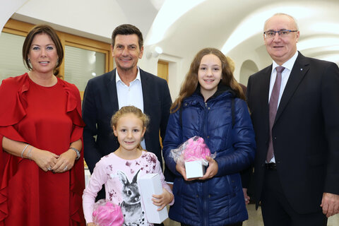 Vorstandsmitglied Andrea Maller-Weiß, Landesrat Christian Illedits, Bianca und Valerie mit ihren Geschenken zum Weltspartag und Vorstandsdirektor Gerhard Nyul.