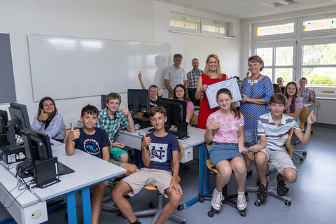 Bildungslandesrätin Daniela Winkler freut sich mit Werner Zwickl (SQM Neusiedl am See), Isabell Lichtenberger, Direktorin MS Kitttsee, und Schülerinnen und Schüler über die Auszeichnung