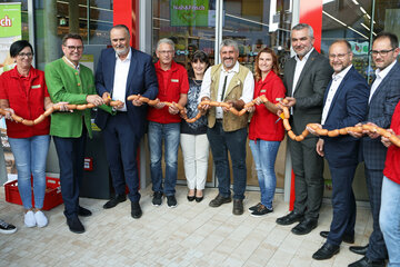 Landeshauptmann Hans Peter Doskozil (4.v.l.), Landesrat Heinrich Dorner (4.v.r.) mit Bürgermeister Erich Trummer (3.v.l.) sowie allen Protagonisten und Beteiligten bei der Eröffnung. Statt einem Roten Band wurde ganz offiziell ein langes "Knacker"-Kränzchen durchgeschnitten.