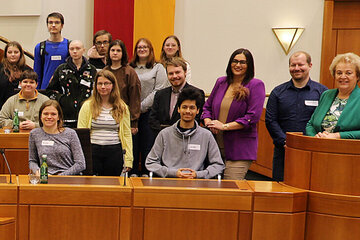 Landtagspräsidentin Verena Dunst (r.) und Landeshauptmann-Stv. Mag.a Astrid Eisenkopf (3.v.r.) und Auslandsdiener Jonathan Dorner (4.v.r. stehend) mit Professorin Mag. Theres Wiedeschitz, BA (l.) und Professor DI (FH) Jürgen Kollmann (2.v.r.) sowie den Schülerinnen und Schülern der Keramikschule Stoob im Landtagssitzungssaal.
