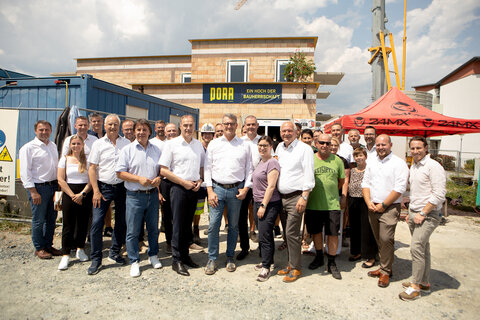 Landesrat Dr. Leonhard Schneemann mit allen Beteiligten Ehrengästen und Mitarbeitern der Baufirma PORR bei der Gleichenfeier in Olbendorf.