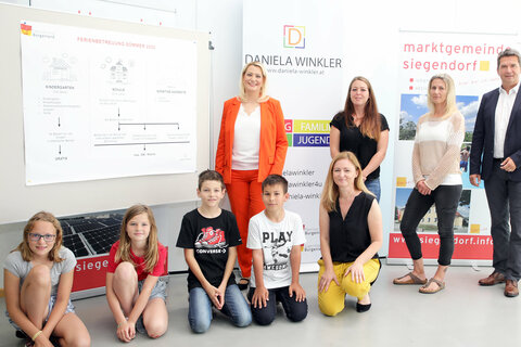 Bildungslandesrätin Mag.a (FH) Daniela Winkler präsentierte mit MS Direktorin LAbg. Rita Stenger, BEd, und Bürgermeister Mag. Rainer Porics die Details zur Ferienbetreuung (im Bild nach PK gemeinsam mit Kinder am Hartplatz der Schule)