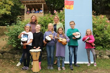 Bildungslandesrätin Mag.a (FH) Daniela Winkler (2. Reihe, r.) übergab Klassenlehrerin Angelika Gröbl (2. Reihe, l.) sowie Schülerinnen und Schülern der dritten und vierten Klasse Musikinstrumente für den Unterricht in der Sonnenland Schule in Eisenstadt;
