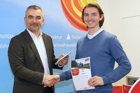 Verkehrslandesrat Heinrich Dorner gratuliert dem Hauptgewinner der diesjährigen Aktion Winterradeln Marlon Kögl aus Neufeld