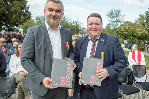 Landesrat Feuerwehrreferent Mag. Heinrich Dorner und Landtagsabgeordneter Bürgermeister Roman Kainrath (v.l.) mit der erstellten Chronik anlässlich des 135-jährigen Jubiläums.