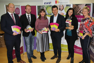 Soziallandesrat Christian Illedits, Bezirkshauptmann-Stellvertreter Mag. Werner Karner, die Journalistin Mag. Ursula Neubauer und die Fotografin Birgit Machtinger sowie anwesende VertreterInnen des RMB bzw. des AMS bei der Eröffnung der Wanderausstellung „Pflege ist mein Alltag“ in der Bezirkshauptmannschaft Mattersburg