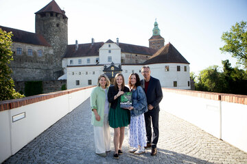 KBB Geschäftsführerin Claudia Priber, Sophie, Jana und Norbert Darabos, Präsident des Österreichischen Friedenszentrums (ACP) vor Burg Schlaining mit dem Buch „Sichtbar machen. Erinnerungslandschaft – Orte und Zeichen des Gedenkens an die Opfer des Nationalsozialismus im Burgenland“ von Herbert Brettl.