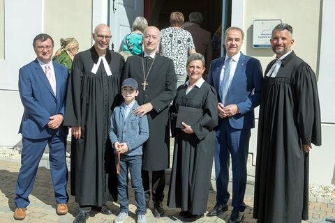 Superintendentialkuratorin-Stellvertreter Süd Mag. Herwig Wallner, Pfarrer Dr. Gerhard Harkam, Superintendent Mag. Dr. Robert Jonischkeit mit seinem Sohn, Lektorin FI Dipl.Päd. Andrea Postmann, Landesrat Dr. Leonhard Schneemann und Pfarrer Dr. Patrick Todjeras (v.l.).