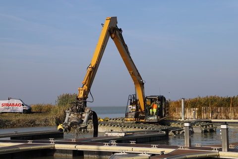 Amphibienbagger bei Arbeiten im Hafen von Podersdorf beim Start des Pilotprojekts zur Schlamm- und Schilfbeseitigung.